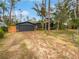 Home with a black garage and a long driveway, surrounded by trees at 14421 Parker Rd, Orlando, FL 32832