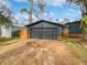 Black garage door with wood accents and a large driveway at 14421 Parker Rd, Orlando, FL 32832