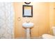 Simple pedestal sink and toilet in a yellow bathroom at 1601 New York Ave., St Cloud, FL 34769