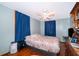 Bedroom with a double bed, dark blue curtains, and hardwood floors at 1601 New York Ave., St Cloud, FL 34769