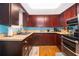 Kitchen with dark wood cabinets, light blue backsplash, and stainless steel appliances at 1601 New York Ave., St Cloud, FL 34769