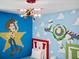 Close-up of Toy Story themed bedroom ceiling fixture and wall art at 1808 Sandy Park Trl, Kissimmee, FL 34747