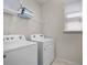 Bright laundry room with washer, dryer, and shelving at 1808 Sandy Park Trl, Kissimmee, FL 34747