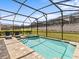 Enclosed pool and spa with lounge chairs at 1808 Sandy Park Trl, Kissimmee, FL 34747