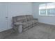 Living room featuring a gray reclining sofa and carpeted floor at 2229 Shadowland Loop, Winter Park, FL 32792