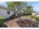 An outdoor view of the backyard with a mulched ground cover and a tree at 2459 Hunterfield Rd, Maitland, FL 32751