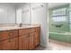 Bathroom featuring a vanity with storage and a tiled tub with fixtures at 2459 Hunterfield Rd, Maitland, FL 32751