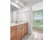 Cozy bathroom featuring a vanity with storage, and a tiled tub with fixtures at 2459 Hunterfield Rd, Maitland, FL 32751