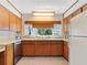 Well-lit kitchen featuring wooden cabinets, a stainless steel dishwasher, and a charming window view at 2459 Hunterfield Rd, Maitland, FL 32751