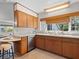 Bright kitchen with wooden cabinets, stainless steel dishwasher, and a window overlooking the backyard at 2459 Hunterfield Rd, Maitland, FL 32751