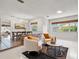 Open-concept living room with dining area, modern lighting, and brick room divider feature at 2459 Hunterfield Rd, Maitland, FL 32751