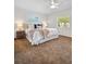 Cozy main bedroom with a plush bed, ceiling fan, and natural light from the windows at 2459 Hunterfield Rd, Maitland, FL 32751