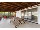 Covered patio featuring a dining area, a lounge area, and a wooden beam ceiling at 2459 Hunterfield Rd, Maitland, FL 32751