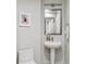 Bathroom featuring a pedestal sink, framed mirror, and a white toilet at 260 S Osceola Ave # 1001, Orlando, FL 32801