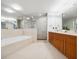 Bright bathroom features a large mirror over the double vanity, a soaking tub, and a glass shower at 260 S Osceola Ave # 1001, Orlando, FL 32801