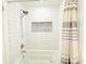 Clean white tiled shower with pebble accent and tub at 2827 Sanctuary Ln, Winter Garden, FL 34787
