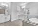 Bright bathroom with double vanity, soaking tub, tiled floors, and glass enclosed shower at 2983 Arranmore Dr, Ormond Beach, FL 32174