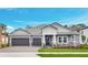 Beautiful single-story home featuring a two-car garage, stone accents, and manicured lawn under a clear blue sky at 2983 Arranmore Dr, Ormond Beach, FL 32174