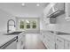 White cabinets, stainless steel appliances, modern faucet, and an island define this airy and stylish kitchen at 2983 Arranmore Dr, Ormond Beach, FL 32174
