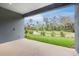 Outdoor covered patio overlooking a beautifully landscaped lawn with mature trees and shrubs at 2983 Arranmore Dr, Ormond Beach, FL 32174