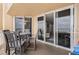 Balcony with table and chairs, and sliding doors leading to the living room at 421 S Atlantic Ave # 105, New Smyrna Beach, FL 32169