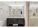 Bright bathroom featuring a double vanity with marble countertop and a glass-enclosed shower at 421 S Atlantic Ave # 105, New Smyrna Beach, FL 32169