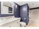Charming bathroom featuring a blue wall, a vanity with marble countertop, and a shower-tub combo at 421 S Atlantic Ave # 105, New Smyrna Beach, FL 32169