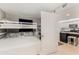 This bedroom features a white bunk bed adjacent to an ensuite kitchen at 421 S Atlantic Ave # 105, New Smyrna Beach, FL 32169