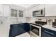 Updated kitchen featuring stainless steel appliances, white subway tile, and navy cabinets at 421 S Atlantic Ave # 105, New Smyrna Beach, FL 32169