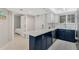 Modern kitchen features navy cabinets, stainless steel appliances, and access to a bedroom at 421 S Atlantic Ave # 105, New Smyrna Beach, FL 32169