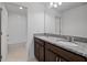 En-suite bathroom with double vanity, granite countertop, wood cabinetry, and tiled shower at 7100 Cherry Pasture Rd, Groveland, FL 34736