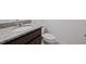 Powder room with a granite countertop, wood cabinetry, and white toilet at 7100 Cherry Pasture Rd, Groveland, FL 34736