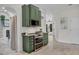 Modern kitchen with green cabinets, stainless steel appliances, and a view to the dining room at 815 E Pine St, Orlando, FL 32801