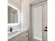 Modern bathroom features white vanity, stylish storage, and a sleek, illuminated mirror at 10750 Sw 110Th St, Dunnellon, FL 34432