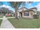 Two-story house with a beige exterior, white garage door, and landscaped lawn at 11513 Robbyes Dr, Orlando, FL 32817