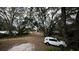 Wooded backyard with gravel driveway and SUV at 13811 County Road 109D, Lady Lake, FL 32159