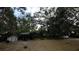 Backyard featuring covered storage, a storage shed and mature trees at 13811 County Road 109D, Lady Lake, FL 32159