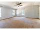 Bedroom with carpet, a ceiling fan, and large windows with exterior views at 13811 County Road 109D, Lady Lake, FL 32159