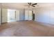 Spacious bedroom with carpet, ceiling fan, and an adjoining bathroom and closet at 13811 County Road 109D, Lady Lake, FL 32159