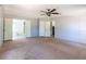 Large bedroom featuring carpeted floors, a ceiling fan, and doorways to other rooms at 13811 County Road 109D, Lady Lake, FL 32159