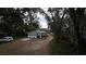 Home's exterior with driveway and surrounding trees at 13811 County Road 109D, Lady Lake, FL 32159