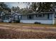 Gray manufactured home with white skirting, wooden steps, and a long driveway at 13811 County Road 109D, Lady Lake, FL 32159
