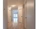 Bright hallway featuring light walls, neutral floors, and multiple doorways at 13811 County Road 109D, Lady Lake, FL 32159