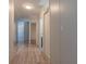 Long hallway featuring light walls and wood-look flooring, leading to various rooms at 13811 County Road 109D, Lady Lake, FL 32159