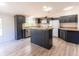 Stylish kitchen showcasing an island, stainless steel appliances, and dark cabinetry at 13811 County Road 109D, Lady Lake, FL 32159