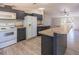 Well-lit kitchen featuring stainless steel appliances, dark cabinets, and a breakfast bar at 13811 County Road 109D, Lady Lake, FL 32159