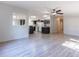 Open living room showcasing seamless flow to kitchen, wood-look floors, and ceiling fan at 13811 County Road 109D, Lady Lake, FL 32159