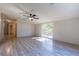Open living room featuring wood-look flooring, sliding glass doors, and a ceiling fan at 13811 County Road 109D, Lady Lake, FL 32159