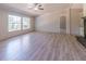 Bright living room featuring wood-look flooring, large windows, and a ceiling fan at 13811 County Road 109D, Lady Lake, FL 32159