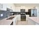 Modern kitchen featuring stainless steel appliances, white cabinetry, gray backsplash, and a bright, quartz countertop at 3151 Paradox Cir # 405, Kissimmee, FL 34746
